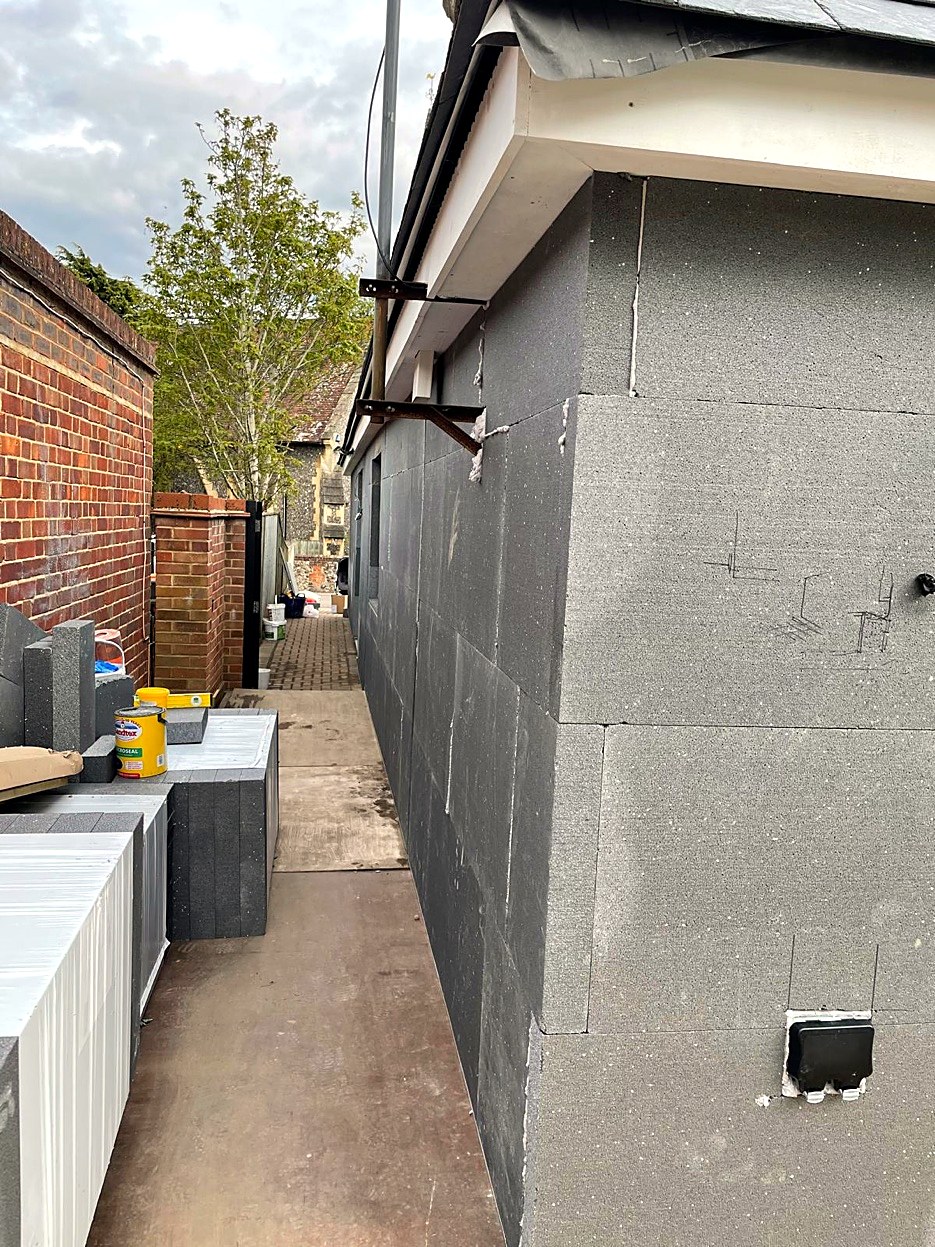 Grey insulation boards fixed to the side of a bungalow