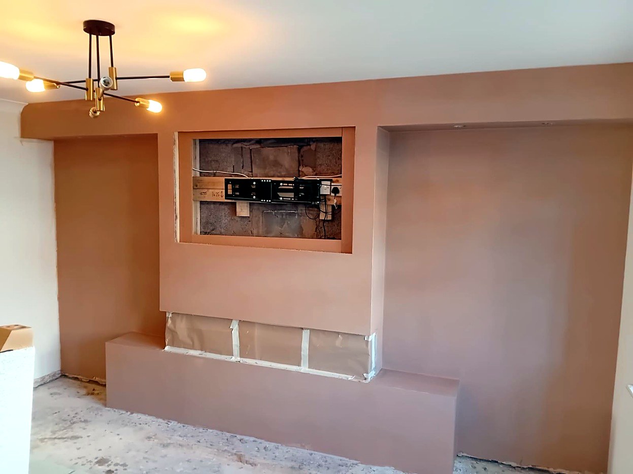 Plastered media wall with a TV recess and alcoves either side
